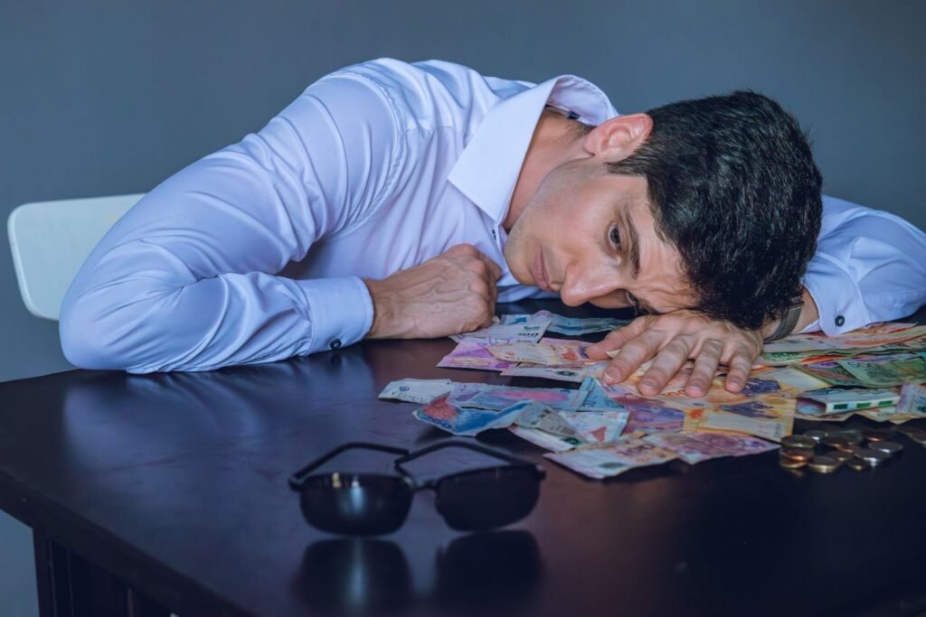 Businessman in white shirt stressed over Argentine currency bills on a table in Buenos Aires.